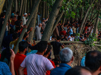 Villagers are watching as SDRF is launching an operation to trace the body of a young man who drowned in Nalla Puhroo while taking a bath on...