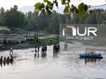 Villagers are watching as SDRF is launching an operation to trace the body of a young man who drowned in Nalla Puhroo while taking a bath on...