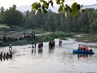 Villagers are watching as SDRF is launching an operation to trace the body of a young man who drowned in Nalla Puhroo while taking a bath on...