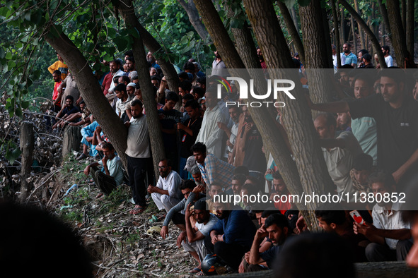 Villagers are watching as SDRF is launching an operation to trace the body of a young man who drowned in Nalla Puhroo while taking a bath on...