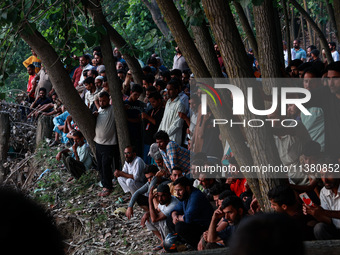 Villagers are watching as SDRF is launching an operation to trace the body of a young man who drowned in Nalla Puhroo while taking a bath on...