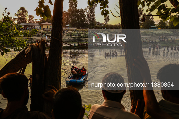 Villagers are watching as SDRF is launching an operation to trace the body of a young man who drowned in Nalla Puhroo while taking a bath on...