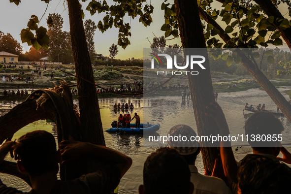 Villagers are watching as SDRF is launching an operation to trace the body of a young man who drowned in Nalla Puhroo while taking a bath on...