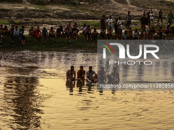 Villagers are watching as SDRF is launching an operation to trace the body of a young man who drowned in Nalla Puhroo while taking a bath on...