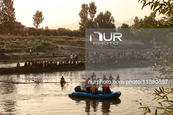 Villagers are watching as SDRF is launching an operation to trace the body of a young man who drowned in Nalla Puhroo while taking a bath on...