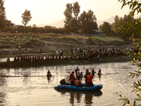 Villagers are watching as SDRF is launching an operation to trace the body of a young man who drowned in Nalla Puhroo while taking a bath on...