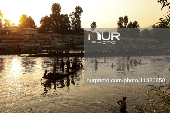 Villagers are watching as SDRF is launching an operation to trace the body of a young man who drowned in Nalla Puhroo while taking a bath on...