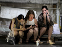 Women are sitting on the ground after the Russian missile strike in Dnipro, Ukraine, on July 3, 2024. At least five people are being reporte...