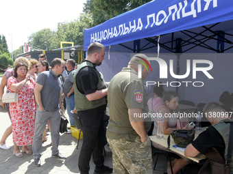 Police officers are helping people near a shopping mall damaged by the Russian missile strike in Dnipro, Ukraine, on July 3, 2024. At least...