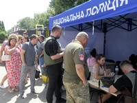 Police officers are helping people near a shopping mall damaged by the Russian missile strike in Dnipro, Ukraine, on July 3, 2024. At least...