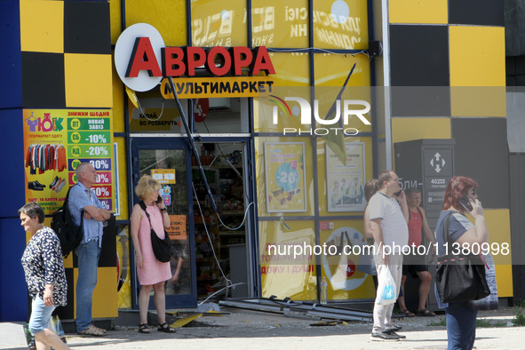 People are standing outside a shop after the Russian missile strike in Dnipro, Ukraine, on July 3, 2024. At least five people are being repo...