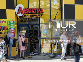 People are standing outside a shop after the Russian missile strike in Dnipro, Ukraine, on July 3, 2024. At least five people are being repo...