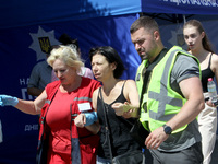 A police officer and paramedic are supporting a woman near a shopping mall during the Russian missile strike in Dnipro, Ukraine, on July 3,...