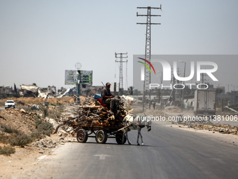 A Palestinian man is using a donkey cart to transport firewood on Salah El Din Street in Deir al-Balah in the central Gaza Strip on July 3,...