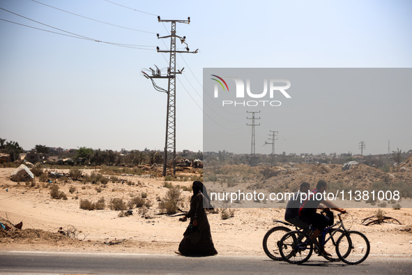 Palestinians are walking on Salah El Din Street in Deir al-Balah in the central Gaza Strip on July 3, 2024, amid the ongoing conflict betwee...