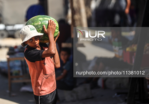 A Palestinian boy is holding a watermelon in Deir al-Balah in the central Gaza Strip on July 3, 2024, amid the ongoing conflict between Isra...