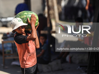 A Palestinian boy is holding a watermelon in Deir al-Balah in the central Gaza Strip on July 3, 2024, amid the ongoing conflict between Isra...