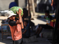 A Palestinian boy is holding a watermelon in Deir al-Balah in the central Gaza Strip on July 3, 2024, amid the ongoing conflict between Isra...