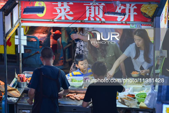 Citizens are enjoying food and leisure time at a night market in Nanjing, China, on July 3, 2024. 