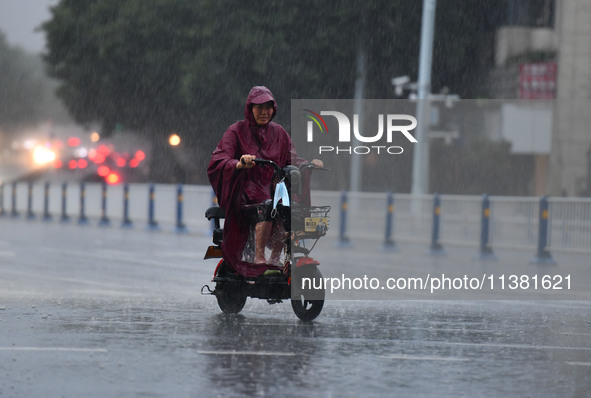 A citizen is riding in a rainstorm in Fuyang, China, on July 4, 2024. On the same day, Fuyang city in Anhui province is suffering heavy rain...