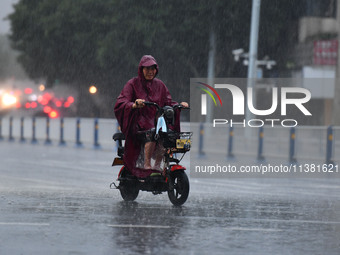 A citizen is riding in a rainstorm in Fuyang, China, on July 4, 2024. On the same day, Fuyang city in Anhui province is suffering heavy rain...