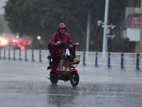 A citizen is riding in a rainstorm in Fuyang, China, on July 4, 2024. On the same day, Fuyang city in Anhui province is suffering heavy rain...