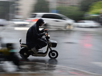 A citizen is riding in a rainstorm in Fuyang, China, on July 4, 2024. On the same day, Fuyang city in Anhui province is suffering heavy rain...