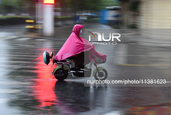 A citizen is riding in a rainstorm in Fuyang, China, on July 4, 2024. On the same day, Fuyang city in Anhui province is suffering heavy rain...