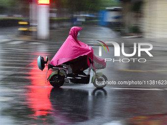 A citizen is riding in a rainstorm in Fuyang, China, on July 4, 2024. On the same day, Fuyang city in Anhui province is suffering heavy rain...