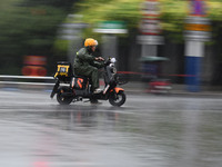 A citizen is riding in a rainstorm in Fuyang, China, on July 4, 2024. On the same day, Fuyang city in Anhui province is suffering heavy rain...