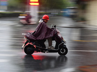 A citizen is riding in a rainstorm in Fuyang, China, on July 4, 2024. On the same day, Fuyang city in Anhui province is suffering heavy rain...