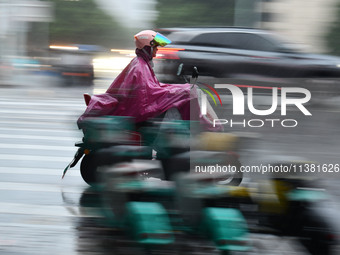 A citizen is riding in a rainstorm in Fuyang, China, on July 4, 2024. On the same day, Fuyang city in Anhui province is suffering heavy rain...