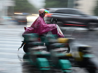 A citizen is riding in a rainstorm in Fuyang, China, on July 4, 2024. On the same day, Fuyang city in Anhui province is suffering heavy rain...