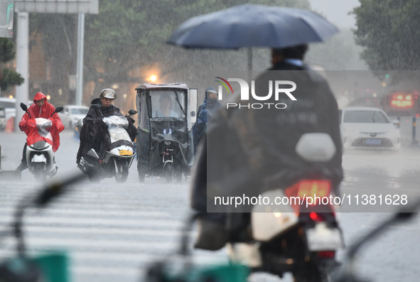 A citizen is riding in a rainstorm in Fuyang, China, on July 4, 2024. On the same day, Fuyang city in Anhui province is suffering heavy rain...