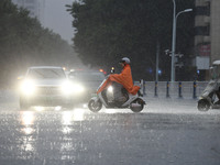 A citizen is riding in a rainstorm in Fuyang, China, on July 4, 2024. On the same day, Fuyang city in Anhui province is suffering heavy rain...