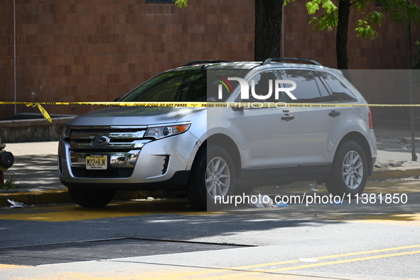 A vehicle is being damaged as a result of the shooting at the crime scene. Two people are being shot in Paterson, New Jersey, United States,...