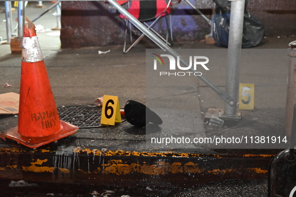 Evidence markers are being placed at the crime scene by the New York City Police Department Crime Scene Unit. One person is being assaulted,...