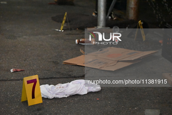 Evidence markers are being placed at the crime scene by the New York City Police Department Crime Scene Unit. One person is being assaulted,...