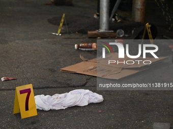 Evidence markers are being placed at the crime scene by the New York City Police Department Crime Scene Unit. One person is being assaulted,...