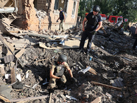 Law enforcers are examining the crater from an impact in a residential area after the Russian glide bomb attack in Kharkiv, Ukraine, on July...