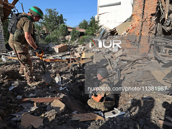 Law enforcers are examining the crater from an impact in a residential area after the Russian glide bomb attack in Kharkiv, Ukraine, on July...