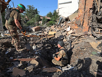 Law enforcers are examining the crater from an impact in a residential area after the Russian glide bomb attack in Kharkiv, Ukraine, on July...