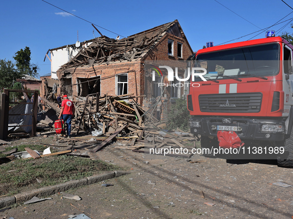 A Ukrainian Red Cross Society representative is standing outside a house destroyed by the Russian glide bomb attack in Kharkiv, Ukraine, on...