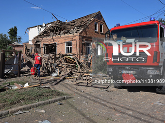 A Ukrainian Red Cross Society representative is standing outside a house destroyed by the Russian glide bomb attack in Kharkiv, Ukraine, on...