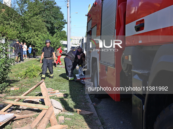 Rescuers are staying by a fire engine in a residential area after the Russian glide bomb attack in Kharkiv, Ukraine, on July 3, 2024. At abo...