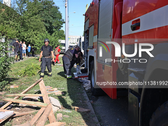 Rescuers are staying by a fire engine in a residential area after the Russian glide bomb attack in Kharkiv, Ukraine, on July 3, 2024. At abo...