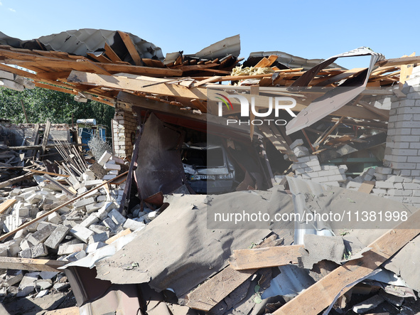 A crashed car is being seen in a destroyed garage in a residential area after the Russian glide bomb attack in Kharkiv, Ukraine, on July 3,...