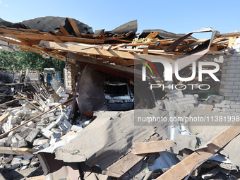 A crashed car is being seen in a destroyed garage in a residential area after the Russian glide bomb attack in Kharkiv, Ukraine, on July 3,...