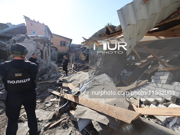 Police officers are examining buildings in a residential area destroyed by the Russian glide bomb attack in Kharkiv, Ukraine, on July 3, 202...