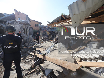 Police officers are examining buildings in a residential area destroyed by the Russian glide bomb attack in Kharkiv, Ukraine, on July 3, 202...